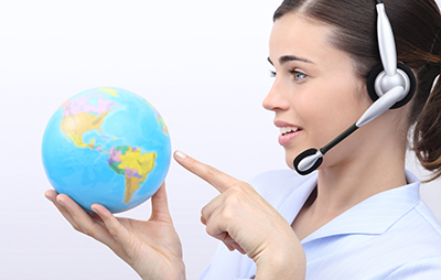 customer service operator woman with headset pointing her finger on globe isolated on white background